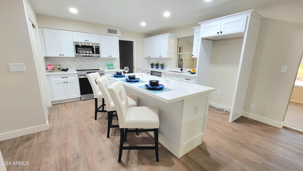 kitchen featuring white cabinets, a center island, sink, and stainless steel appliances