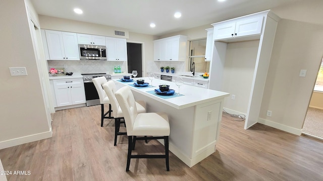 kitchen featuring white cabinets, a center island, sink, and stainless steel appliances