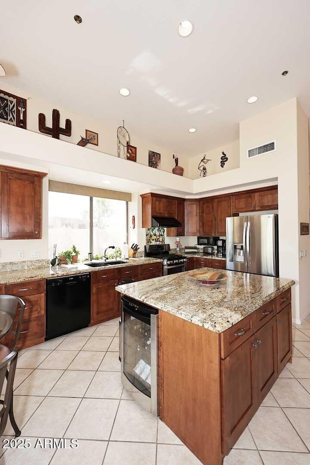 6966 E Bramble Berry Ln, Scottsdale, AZ 85266 - kitchen featuring appliances with stainless steel finishes, wine cooler, light tile patterned floors, a center island, and light stone counters