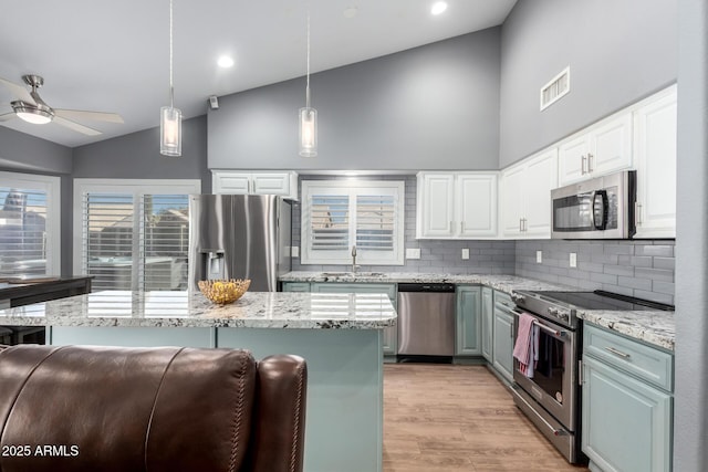 kitchen featuring stainless steel appliances, visible vents, white cabinetry, a sink, and high vaulted ceiling