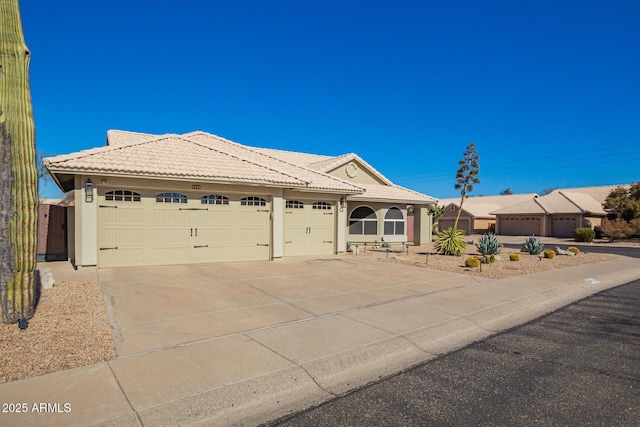 ranch-style house with a garage, a tile roof, concrete driveway, and stucco siding