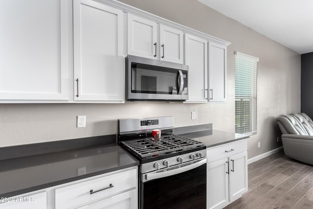 kitchen featuring white cabinets, light wood-type flooring, and stainless steel appliances