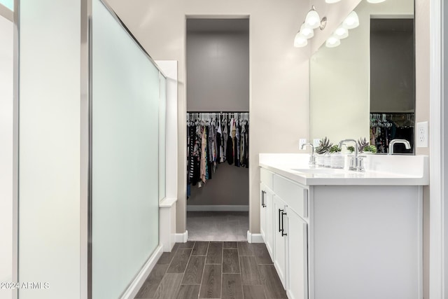 bathroom with wood-type flooring, vanity, and walk in shower