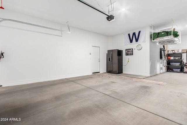 garage featuring black fridge and a garage door opener