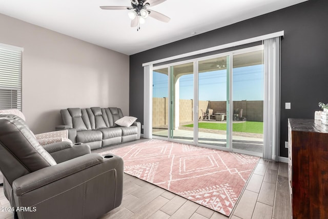 living room with light hardwood / wood-style flooring and ceiling fan