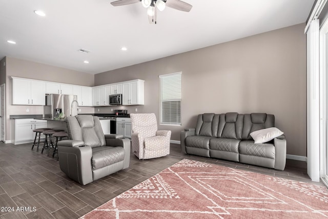 living room with ceiling fan and dark wood-type flooring