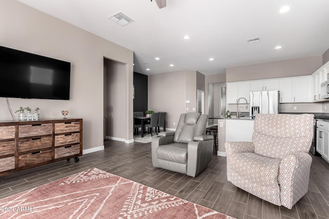 living room with dark hardwood / wood-style flooring and sink