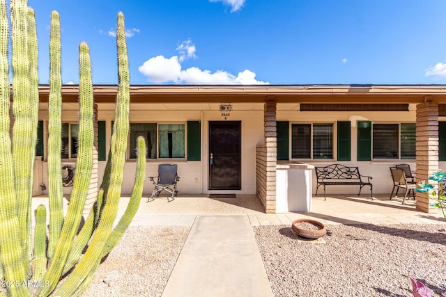 view of front of house featuring a patio area, a fire pit, and a porch