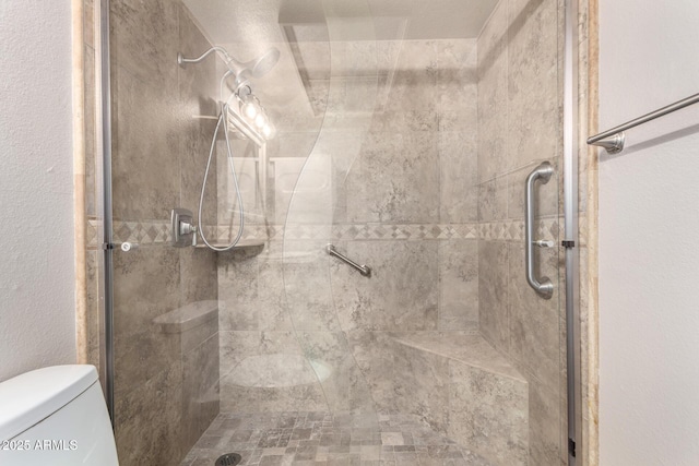 bathroom featuring toilet and a shower stall