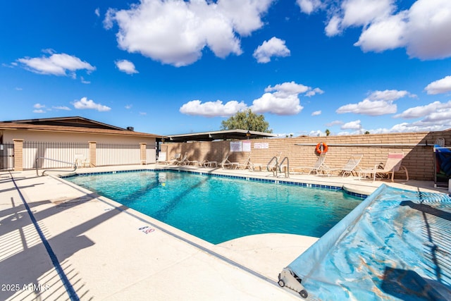 community pool featuring fence and a patio