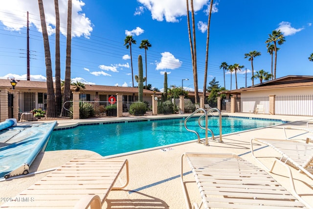 community pool featuring a patio area and fence