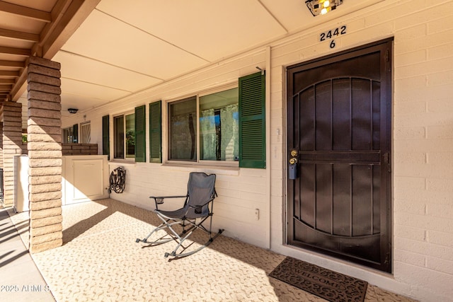 entrance to property with covered porch and concrete block siding