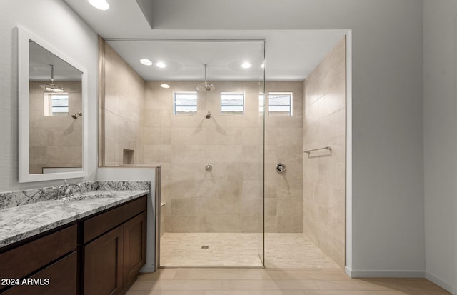 bathroom with tiled shower, hardwood / wood-style floors, and vanity