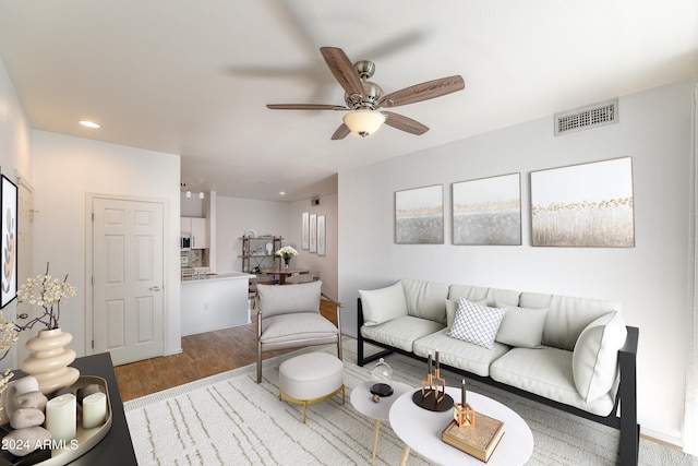 living room with light hardwood / wood-style floors and ceiling fan