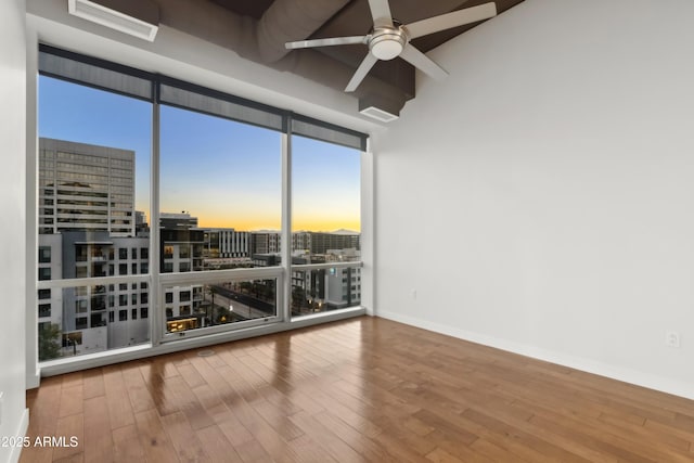 empty room with hardwood / wood-style floors and ceiling fan