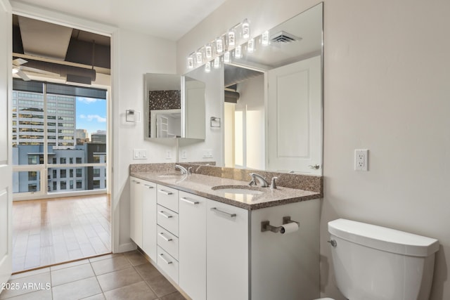 bathroom featuring tile patterned floors, vanity, and toilet