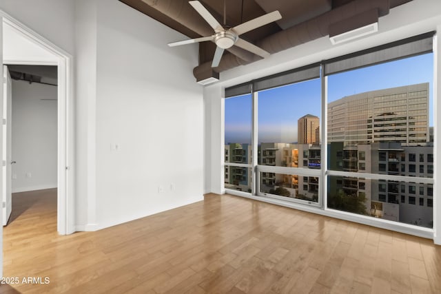 interior space featuring expansive windows, light hardwood / wood-style floors, and ceiling fan