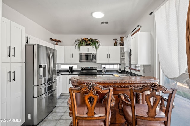 11383 W Pima St, Avondale, AZ 85323 - kitchen with appliances with stainless steel finishes, open shelves, dark countertops, and healthy amount of natural light