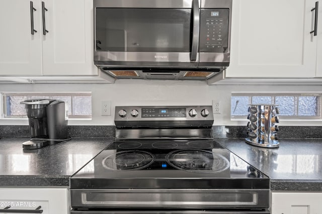 11383 W Pima St, Avondale, AZ 85323 - kitchen with stainless steel microwave, electric range, white cabinets, and dark countertops