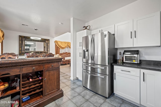 11383 W Pima St, Avondale, AZ 85323 - kitchen with stainless steel refrigerator with ice dispenser, dark countertops, white cabinetry, and light tile patterned floors