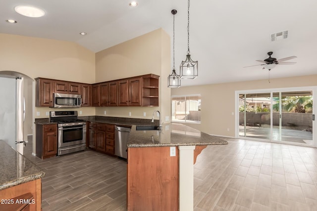 kitchen with kitchen peninsula, appliances with stainless steel finishes, ceiling fan, and sink