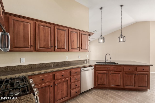 kitchen featuring vaulted ceiling, appliances with stainless steel finishes, hanging light fixtures, kitchen peninsula, and sink