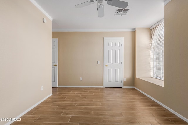 unfurnished room with ceiling fan and crown molding