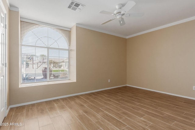 spare room featuring ceiling fan, a wealth of natural light, and crown molding