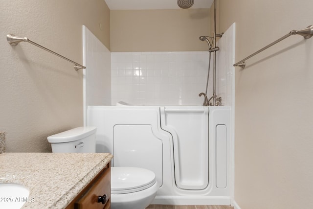 bathroom featuring toilet, vanity, and a bathing tub