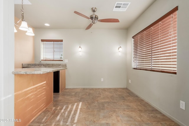 kitchen featuring ceiling fan and pendant lighting