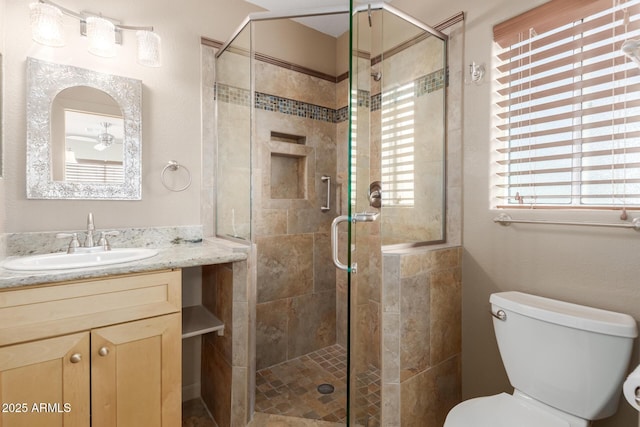 bathroom featuring toilet, an enclosed shower, and vanity