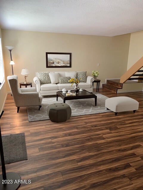 living room featuring a textured ceiling and wood-type flooring