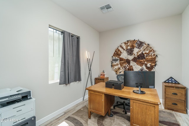 home office with light hardwood / wood-style flooring