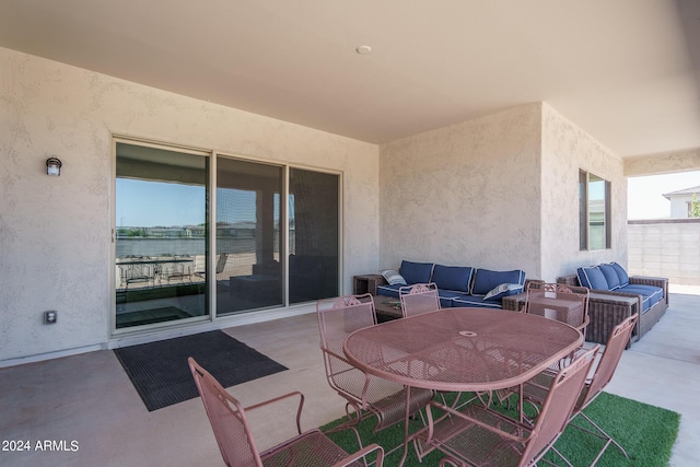 view of patio with a water view and an outdoor living space