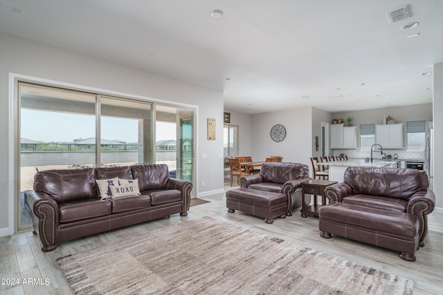 living room with sink and light hardwood / wood-style flooring