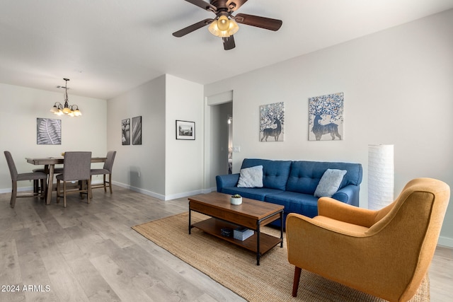 living room with ceiling fan with notable chandelier and light wood-type flooring