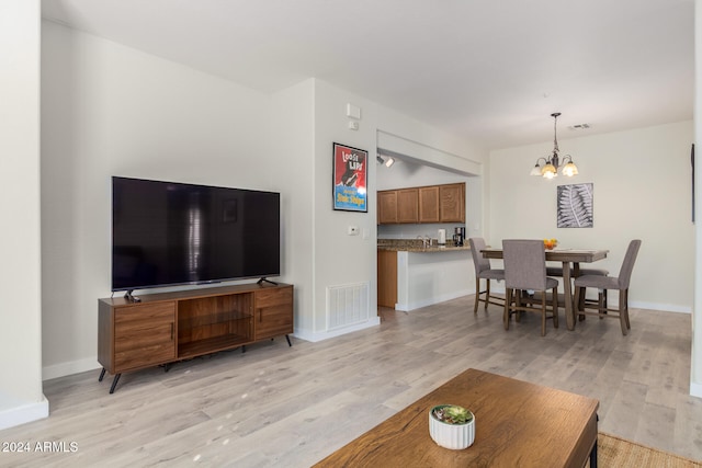 living room with a chandelier and light hardwood / wood-style flooring