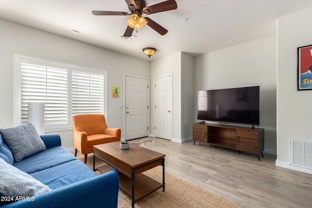 living room featuring light hardwood / wood-style flooring and ceiling fan