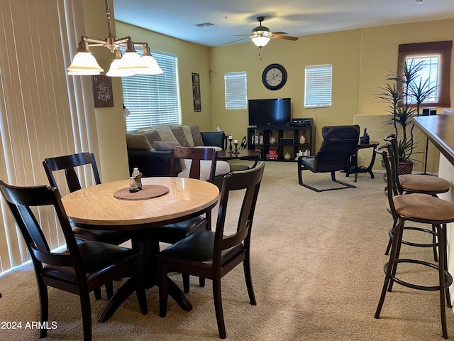 dining space featuring ceiling fan, visible vents, and light carpet