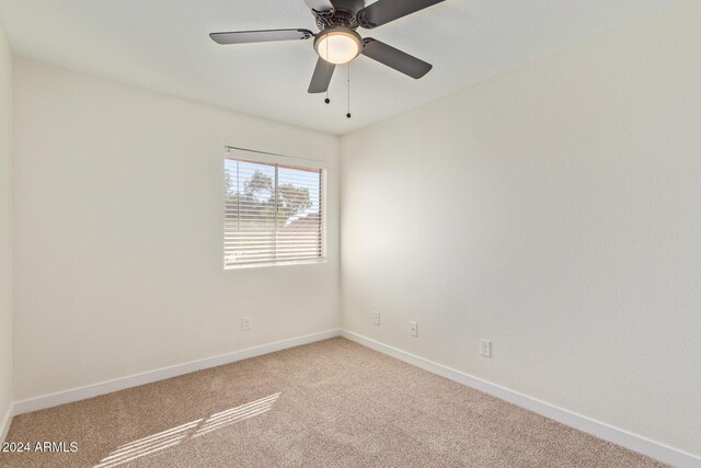 unfurnished room featuring carpet floors, ceiling fan, and baseboards