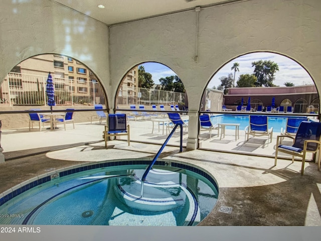 view of swimming pool with a patio area and a community hot tub