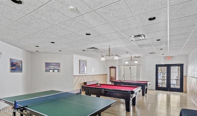 game room featuring a paneled ceiling, light tile patterned floors, pool table, and french doors