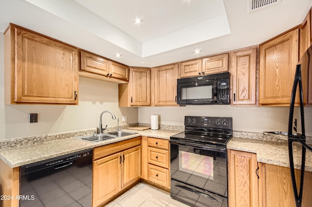 kitchen featuring black appliances, a raised ceiling, sink, light tile patterned flooring, and light stone counters