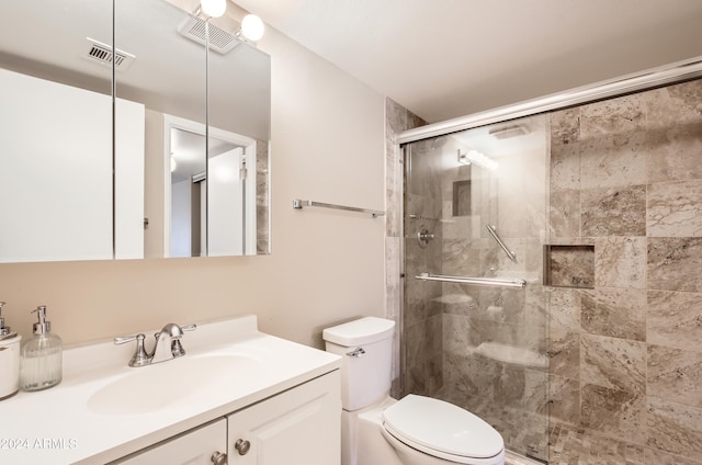 bathroom featuring vanity, an enclosed shower, and toilet