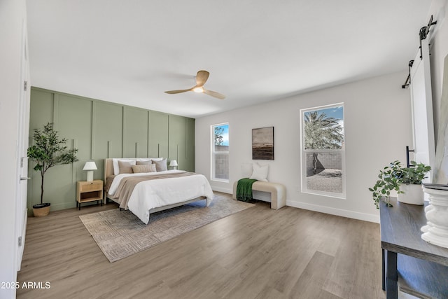 3614 W Danbury Dr, Glendale, AZ 85308 - bedroom with a barn door, wood finished floors, and a ceiling fan