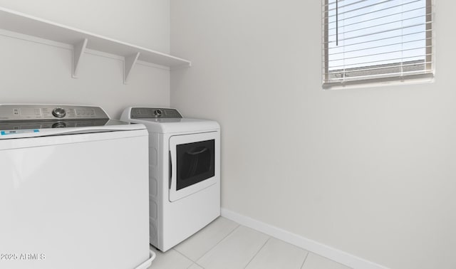 laundry room with washer and dryer and light tile patterned floors