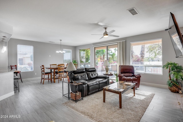 living room featuring ceiling fan with notable chandelier