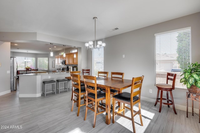 dining room with a chandelier and light wood-type flooring