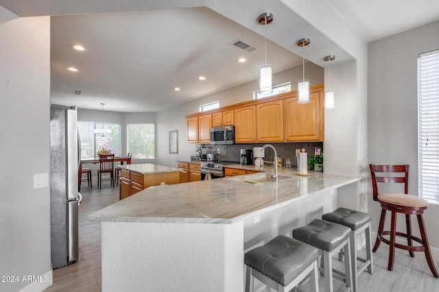 kitchen with a center island, sink, decorative backsplash, kitchen peninsula, and stainless steel appliances