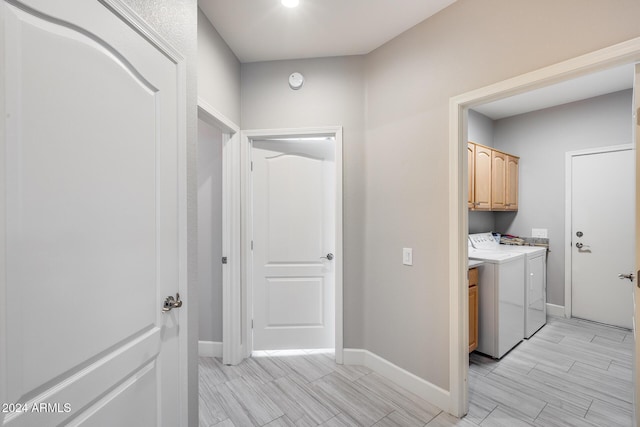 clothes washing area with cabinets and independent washer and dryer